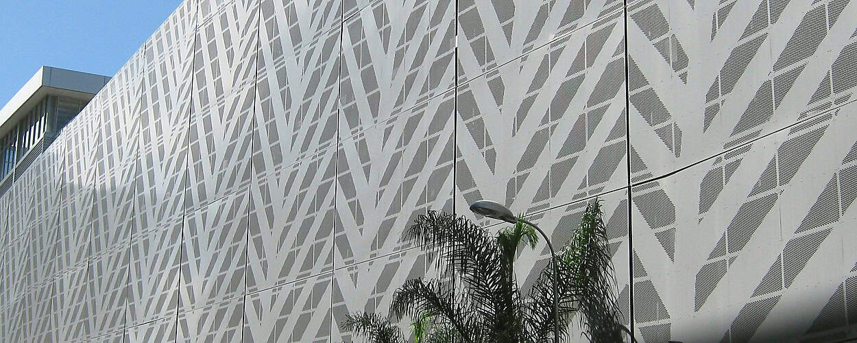 Photo of the side of a carpark clad with a fern patterned aluminium perforated panels